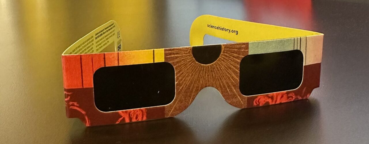 colorful pair of eclipse glasses on a table in the museum gallery