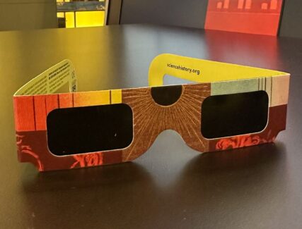 colorful pair of eclipse glasses on a table in the museum gallery