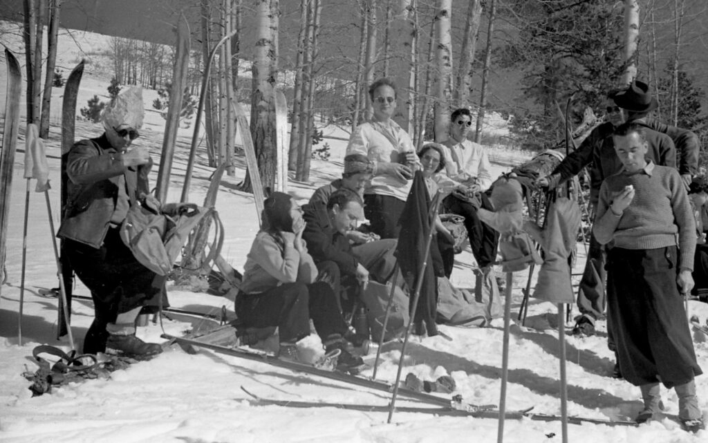 black and white photo of a group of people in the snow in the woods