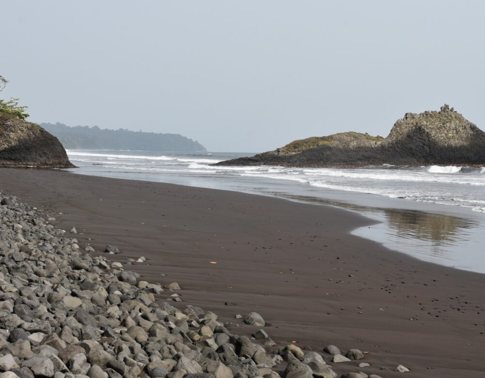 beach with rocks and an island in the distance