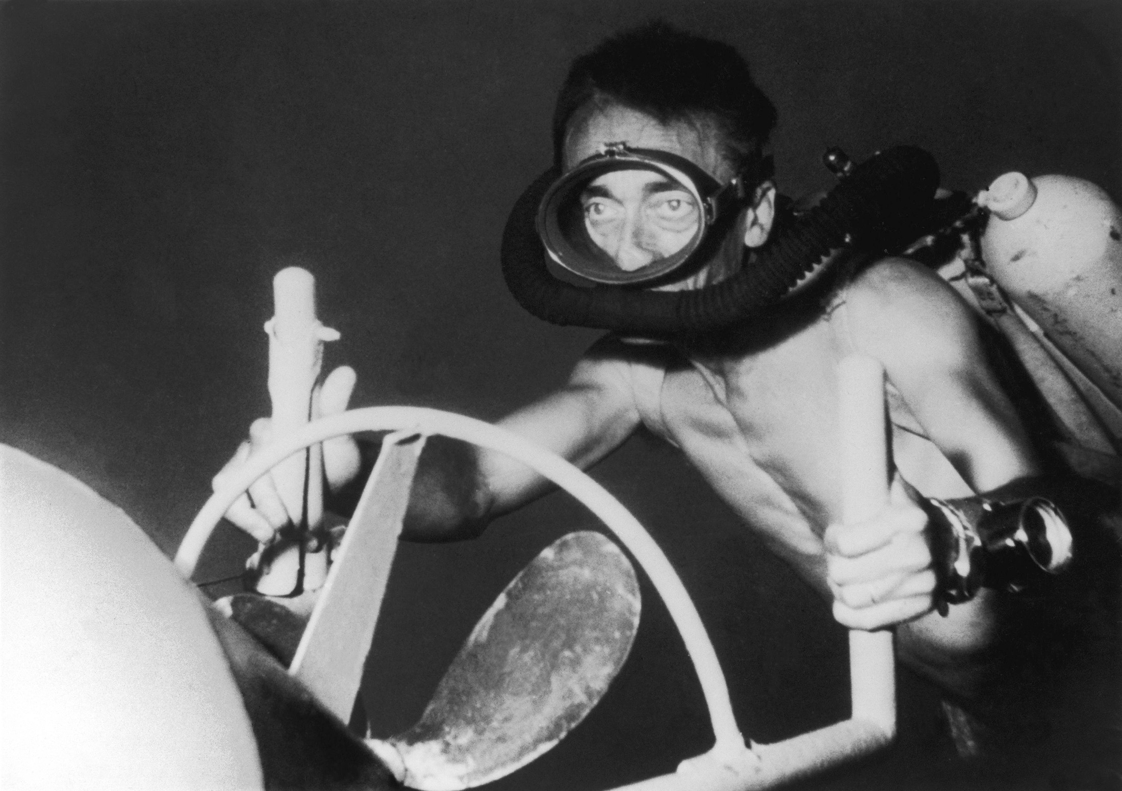 Black and white photo of man in scuba gear underwater