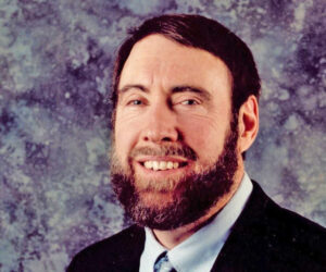 Max McDaniel, smiling, beard, wearing suit and tie