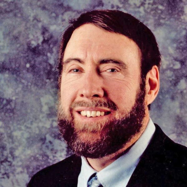 Max McDaniel, smiling, beard, wearing suit and tie