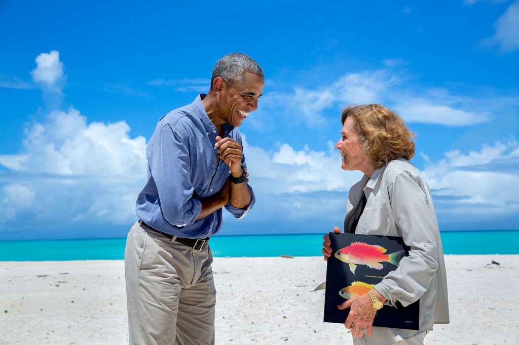 A man and woman talking on a beach