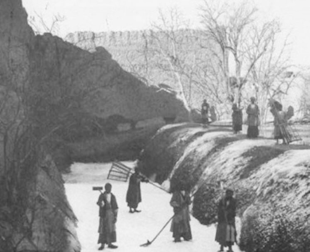 Workers clearing ice from the shallow pool of a Yakhchāl