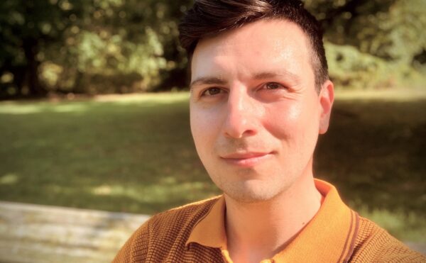 color photo of a man wearing an orange shirt