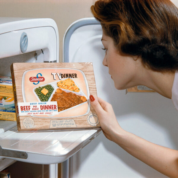 A woman examines a TV dinner box she has taken from the freeze