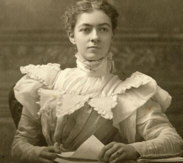b/w photo of a women seated in a dress