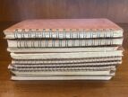 pile of notebooks on a wooden table