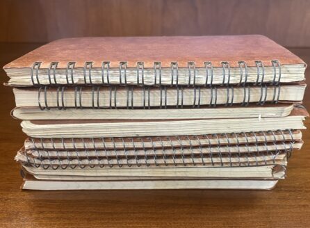 pile of notebooks on a wooden table