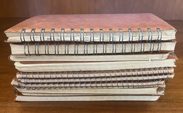 pile of notebooks on a wooden table