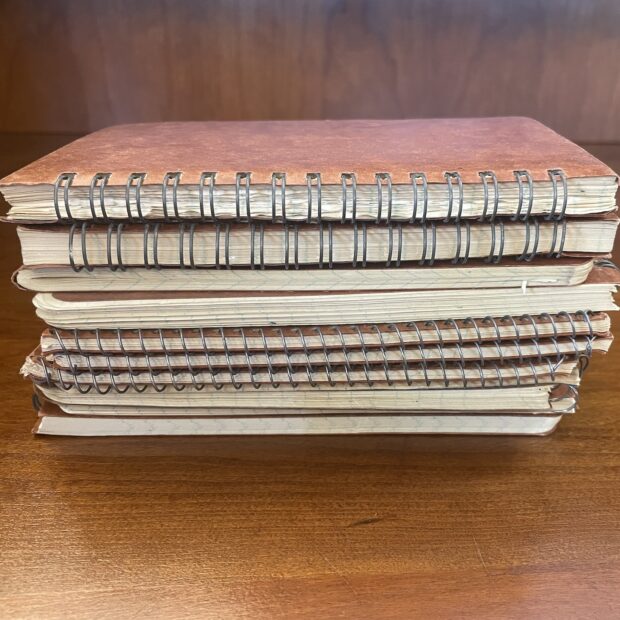 pile of notebooks on a wooden table