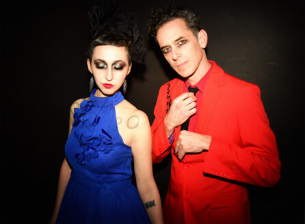 Ellia Bisker and Jeff Morris wearing eclipse glasses in a dark studio