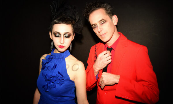 Ellia Bisker and Jeff Morris wearing eclipse glasses in a dark studio