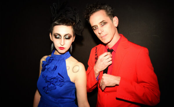 Ellia Bisker and Jeff Morris wearing eclipse glasses in a dark studio