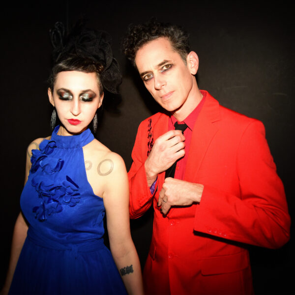 Ellia Bisker and Jeff Morris wearing eclipse glasses in a dark studio