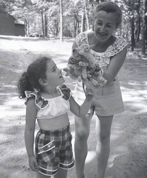 photo of a young girl and a woman holding kittens