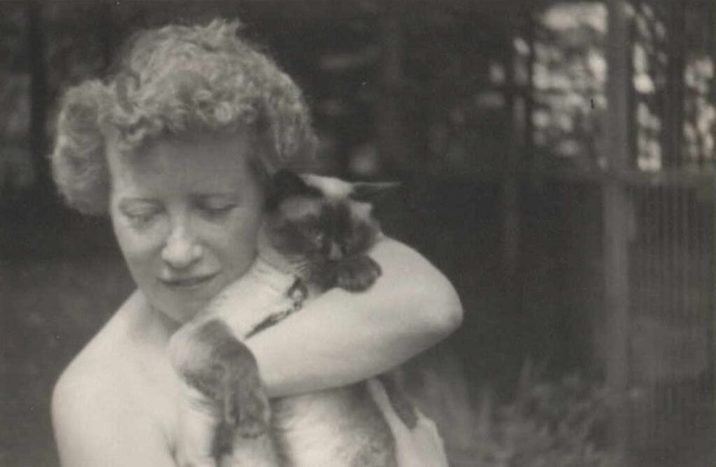 photo of a woman holding a siamese cat