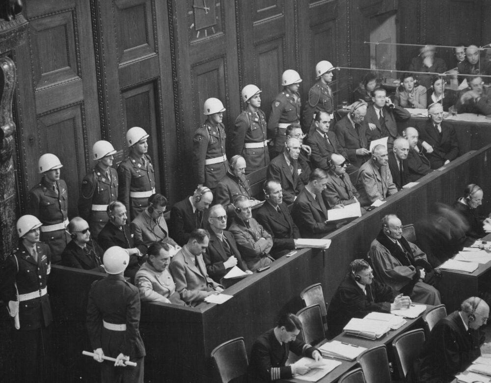 Defendants sitting in blocked off area in court surrounded by military police