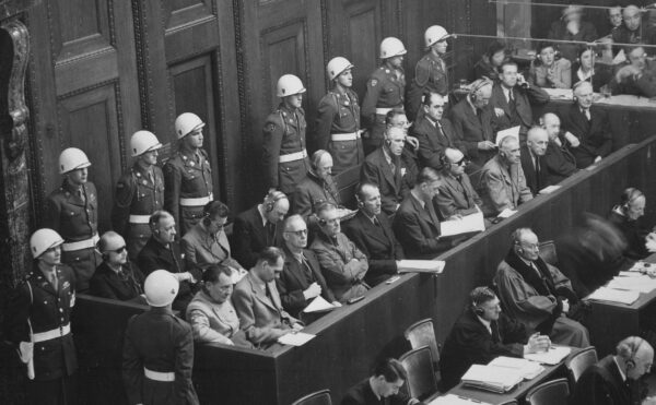 Defendants sitting in blocked off area in court surrounded by military police