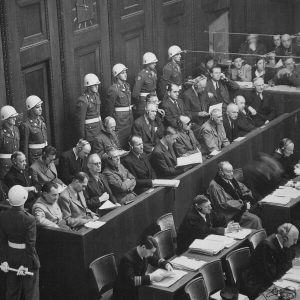 Defendants sitting in blocked off area in court surrounded by military police