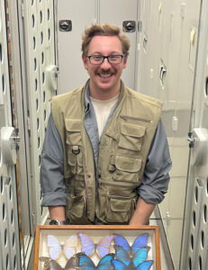man in storage area with butterfly collection