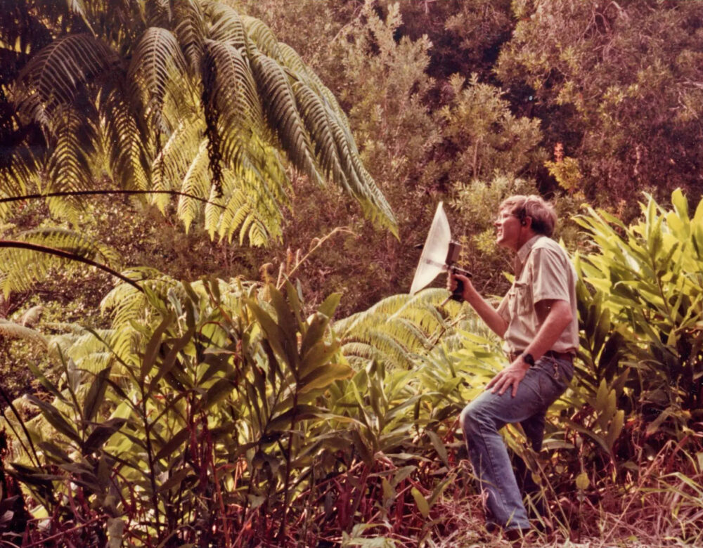 man in tropical forest with hooded camera