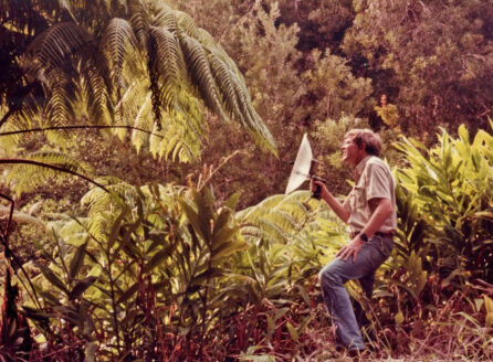 man in tropical forest with hooded camera