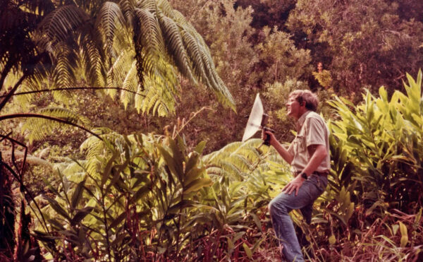 man in tropical forest with hooded camera
