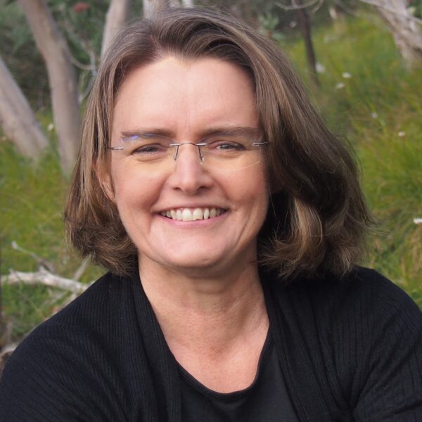 headshot of woman in black shirt wearing glasses