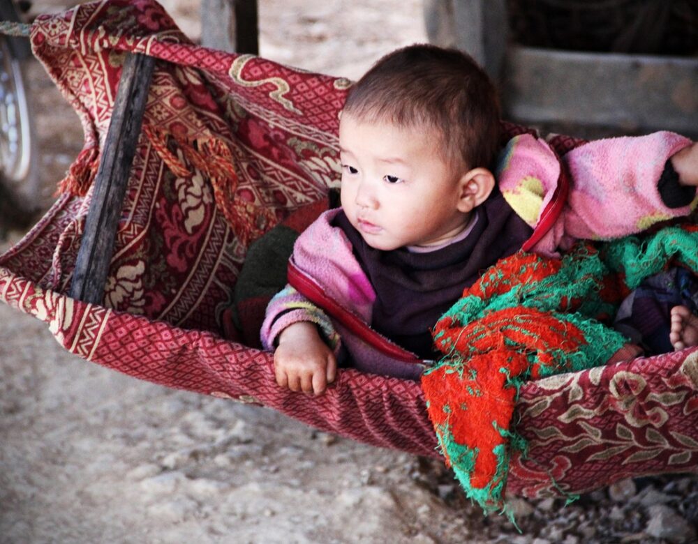 infant in a colorful cradle