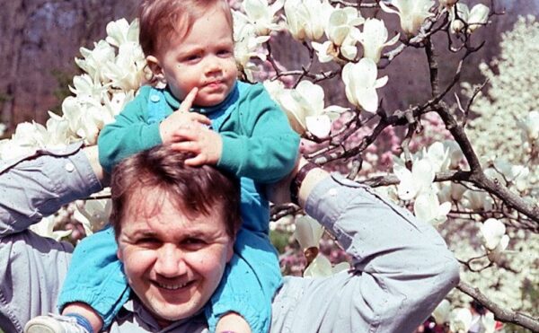 color photo of a man with a baby on his shoulders