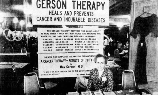 Newspaper photo clipping of a woman seated at a table selling book with a sign titled “Gerson Therapy” above