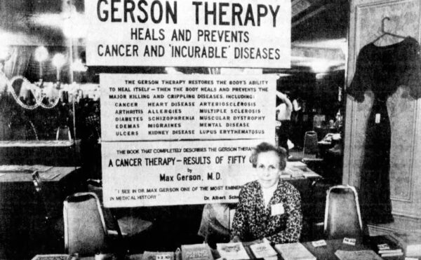Newspaper photo clipping of a woman seated at a table selling book with a sign titled “Gerson Therapy” above