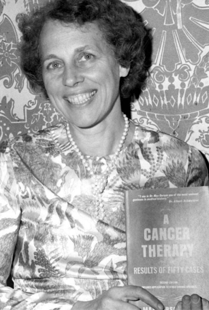 Photo of woman smiling while holding a copy of “A Cancer Therapy”