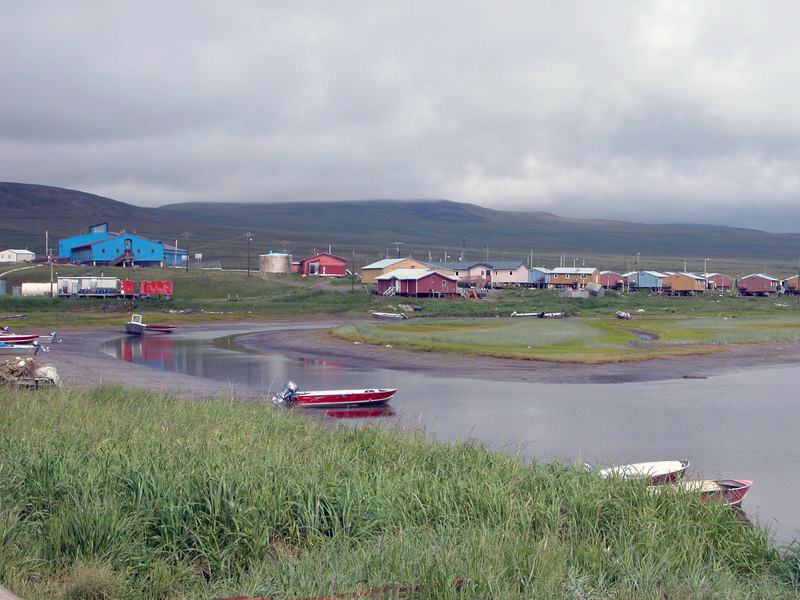 Landscape photograph of creek with scattered single story houses on its shore