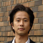 Man in front of brick wall