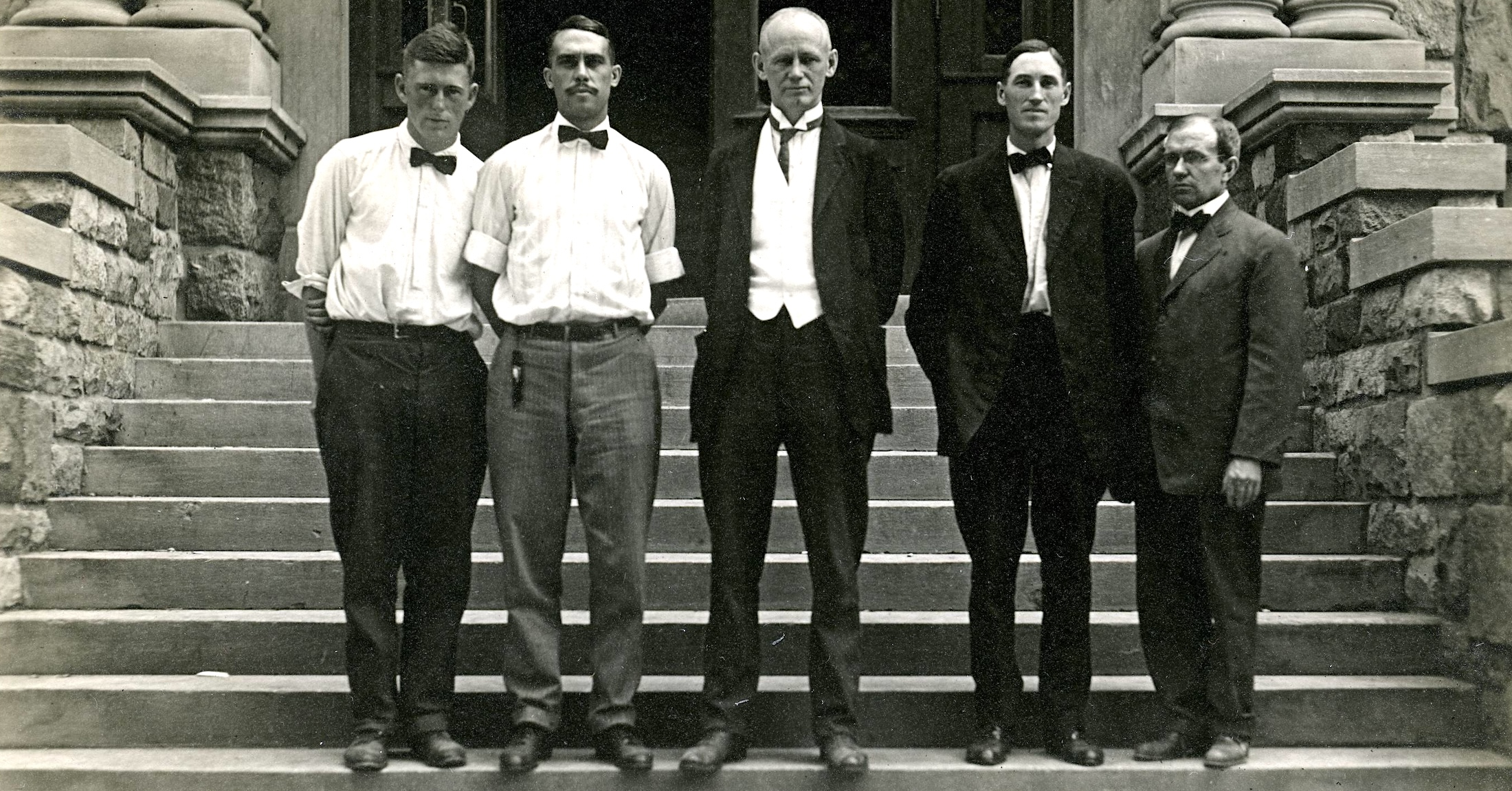 group of 5 men standing on steps