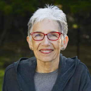 Dava Sobel, outdoors, red glasses, wearing gray and charcoal gray