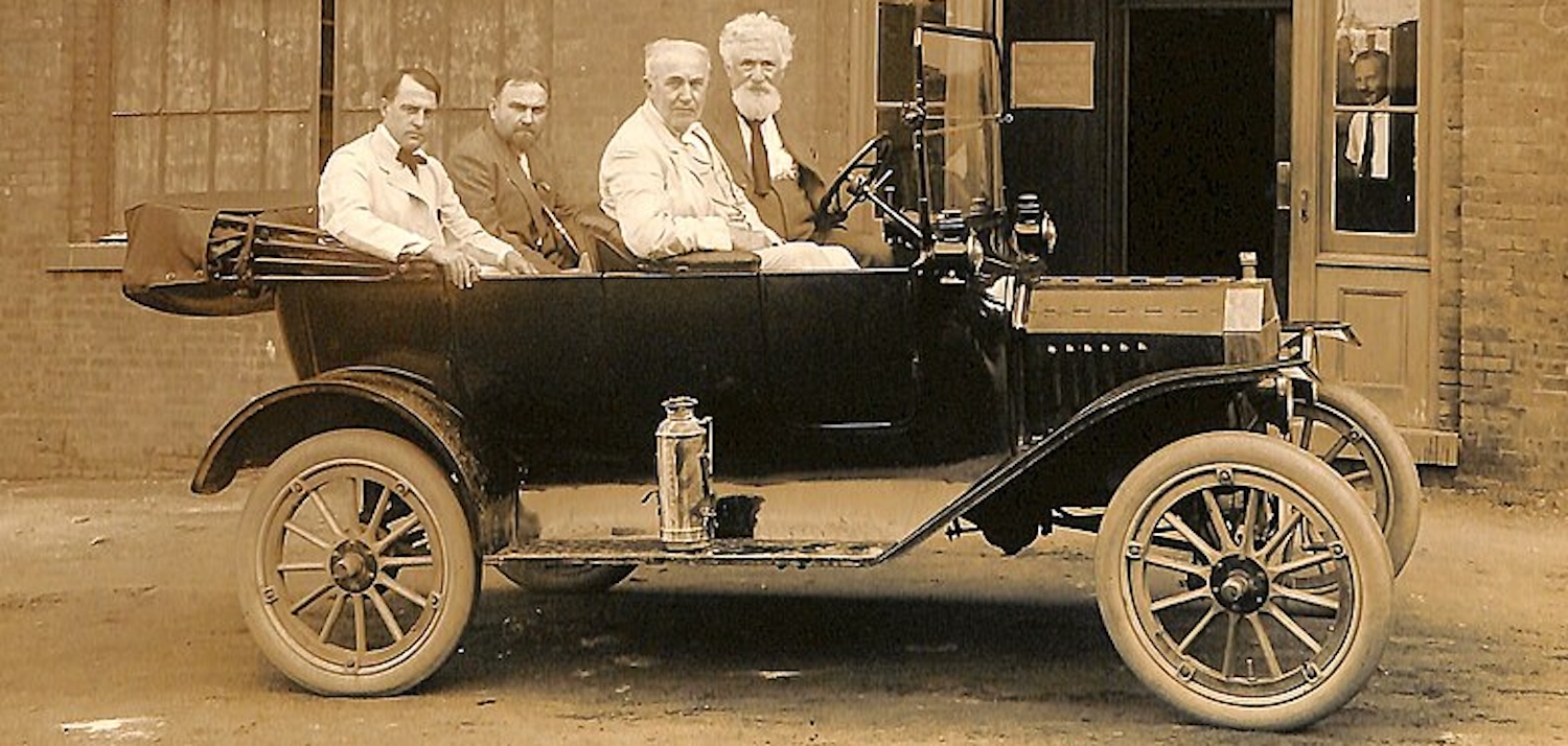 black and white photo of 4 men in an old car