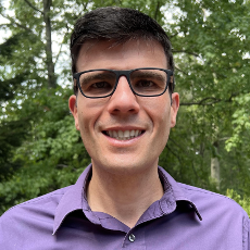 man wearing a purple shirt and glasses