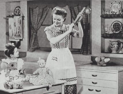 woman holding am insect sprayer while a child looks on