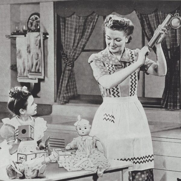 woman holding am insect sprayer while a child looks on