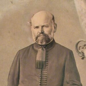 sepia toned portrait of a man in coat and riding boots