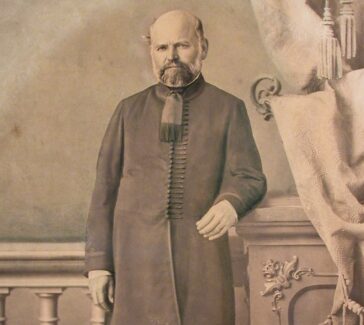 sepia toned portrait of a man in coat and riding boots