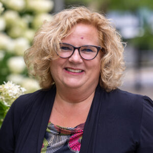 outdoor portrait of a woman with glasses and black blazer