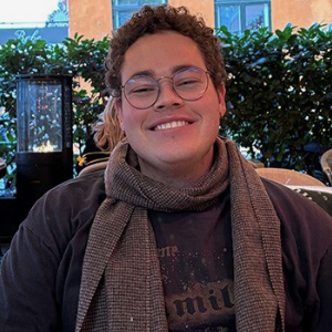 photo of a person wearing round glasses and a scarf