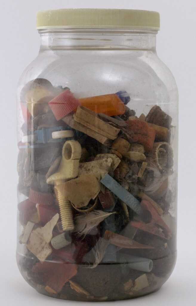 glass jar containing pieces of plastic