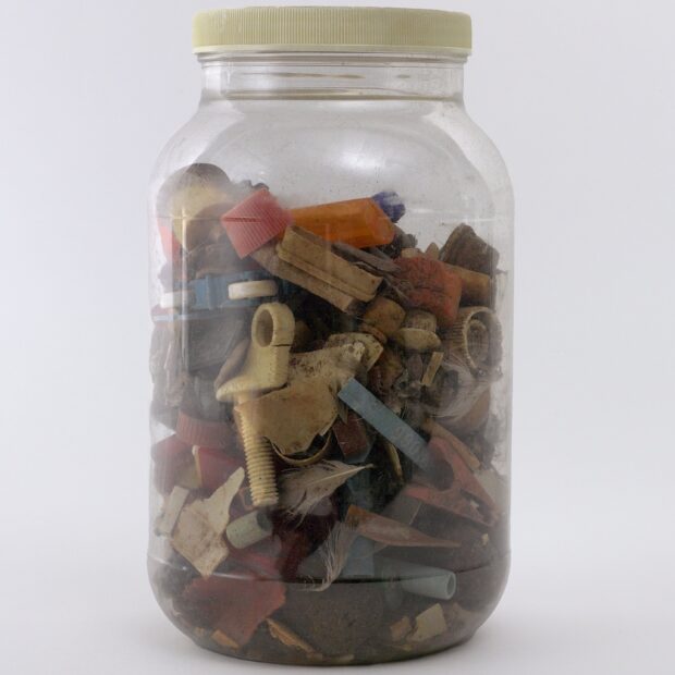 glass jar containing pieces of plastic