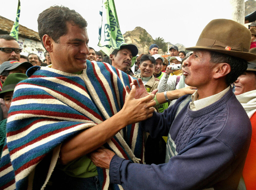 color photograph of two men in a crowd embracing and shaking hands